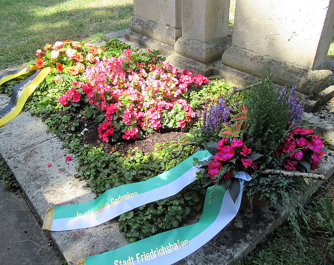 Grab mit Blumenschalen und Schleifen